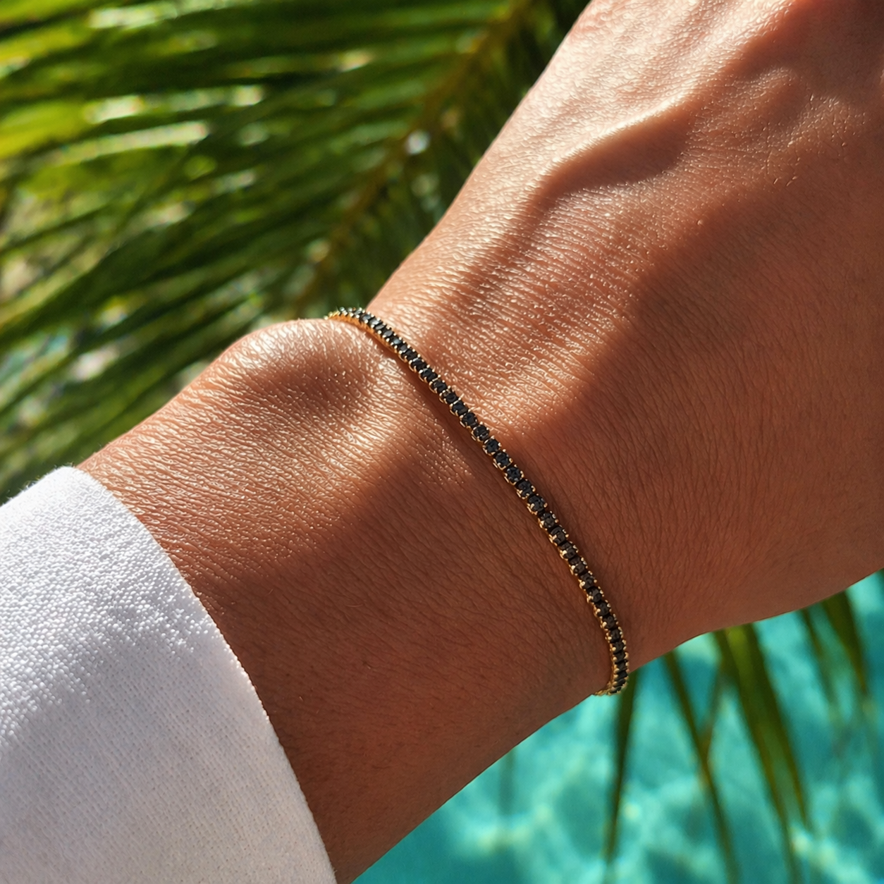 Gouden tennisarmband met zwarte steentjes