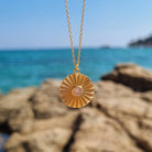 Ketting met hanger verguld zilver muntje voor mooie warme achtergrond met zee - zon - zirkonia